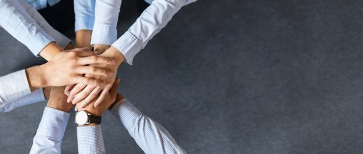 Close up top view of young business people putting their hands together. Stack of hands. Unity and teamwork concept.