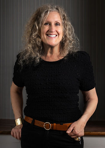 Judith, a woman dressed casually in all black, smiles 